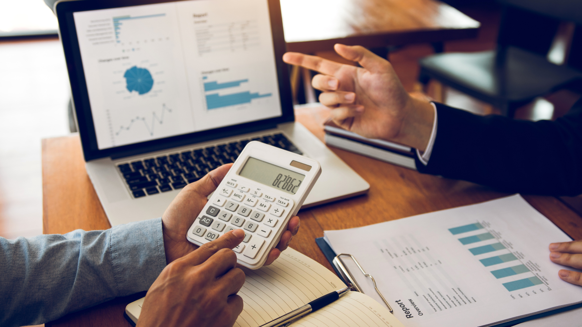 Team discussing cost-saving strategies for government office budgeting using reports and analytics.