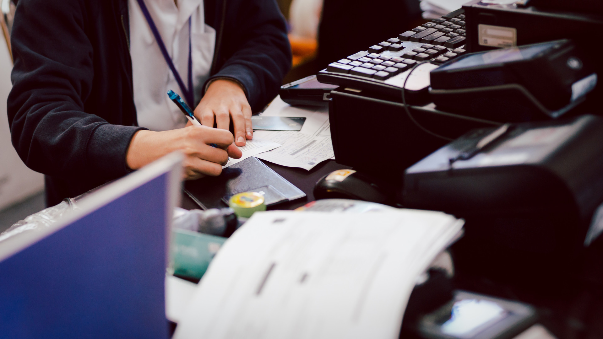 Finance team member at a busy desk, highlighting the need for desk booking for finance workplaces