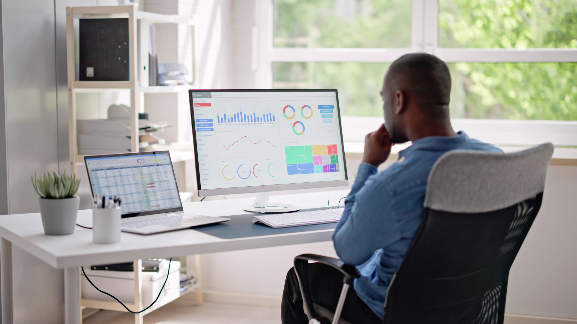 office manager reviewing workplace occupancy analytics dashboard with charts and graphs